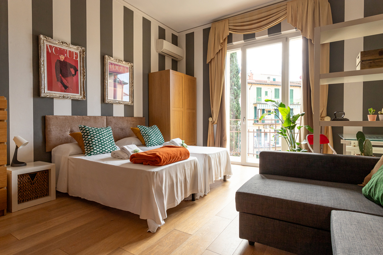 Camera da letto elegante con pareti a strisce e dettagli colorati – appartamento lifestyle