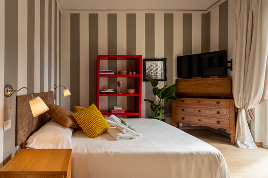 Camera con scaffale rosso e TV – interior photography appartamento